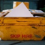 A yellow overloaded container from skip services managing household waste